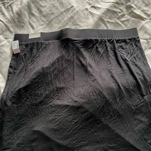 NWT Black cotton stretch skirt with a drawn up accent on left side.